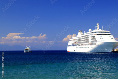 Sea background. A large white passenger cruise ship stands at the tourist seaport, Rhodes, Greece. Liner, water transport for travel, recreation. Sea, ocean landscape, spring, summer vacation.