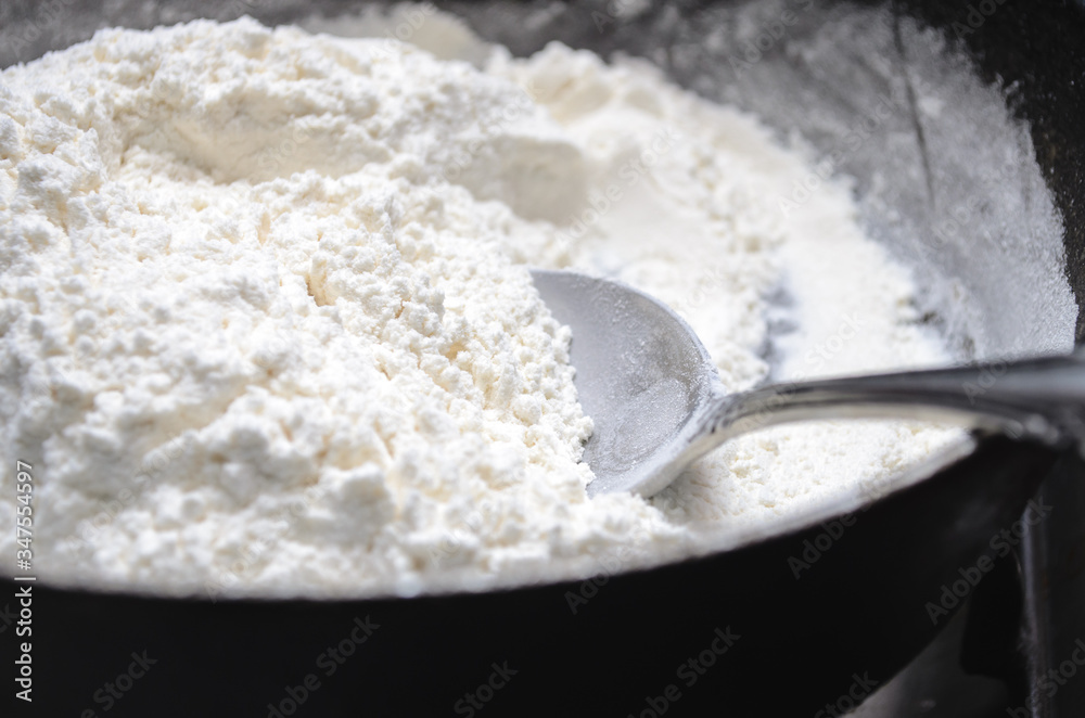 Cooking halva in a frying pan. Flour in a pan with a spoon