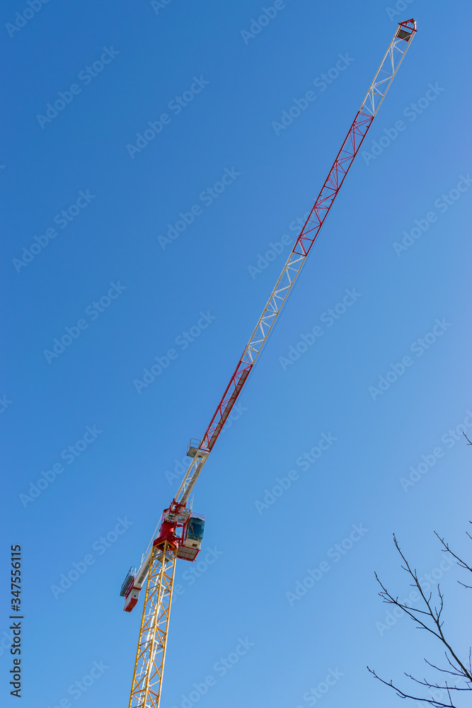 Technology,engineering,modernity and construction progress concept: View of the tower crane against the blue sky.