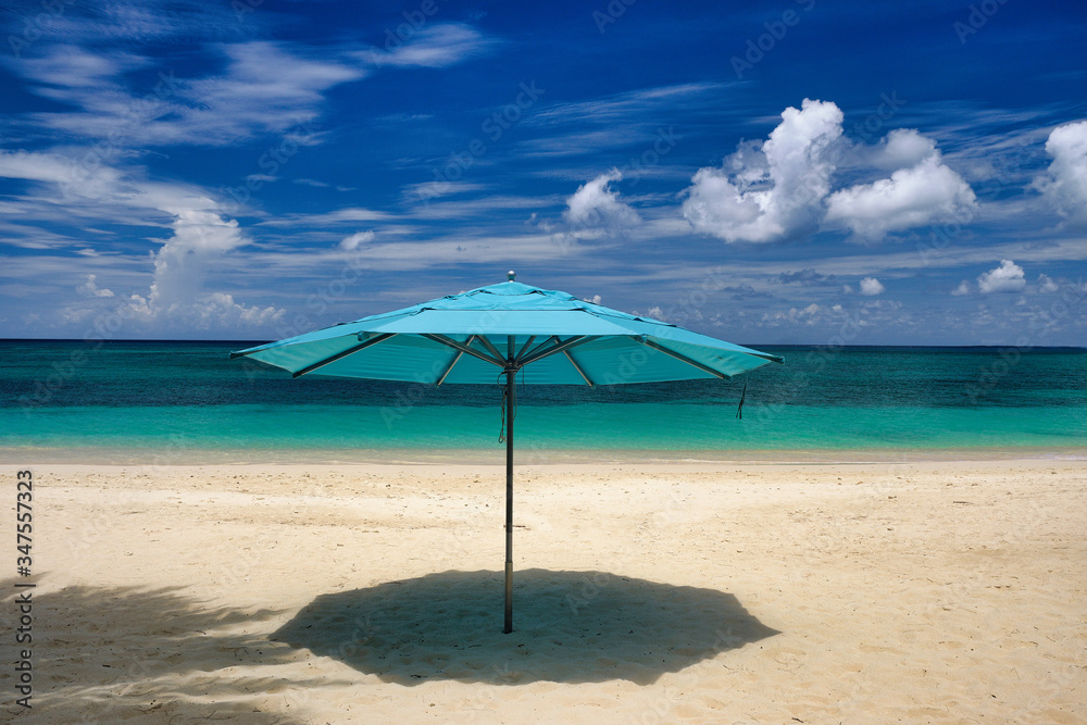 Fototapeta premium Horizontal image of an empty Cayman Island Beach with an open blue beach umbrella