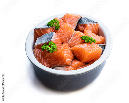 Fresh salmon fillet cubes in clay bowl isolated on white
