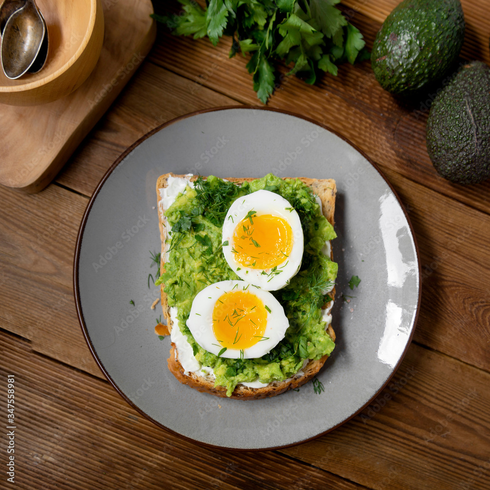 Healthy food. Toast with avocado and egg on wooden background. Square wholegrain bread toast. Healthy food. Toast with avocado and egg on wooden background. Square wholegrain bread toast.