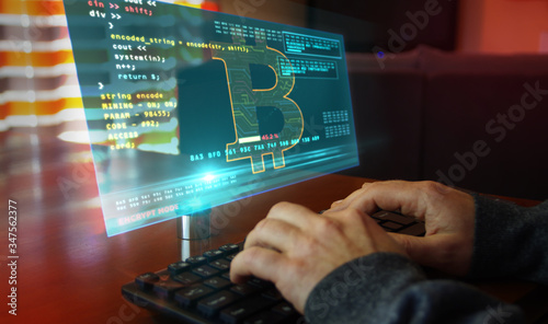 Bitcoin with typing on keyboard and cryptocurrency mining hologram screen