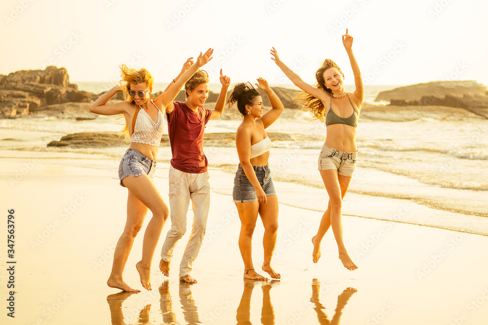 Multi-ethnic group of friends dance at the beach