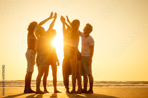 Photography group of friends enjoying sunset in Goa India high five
