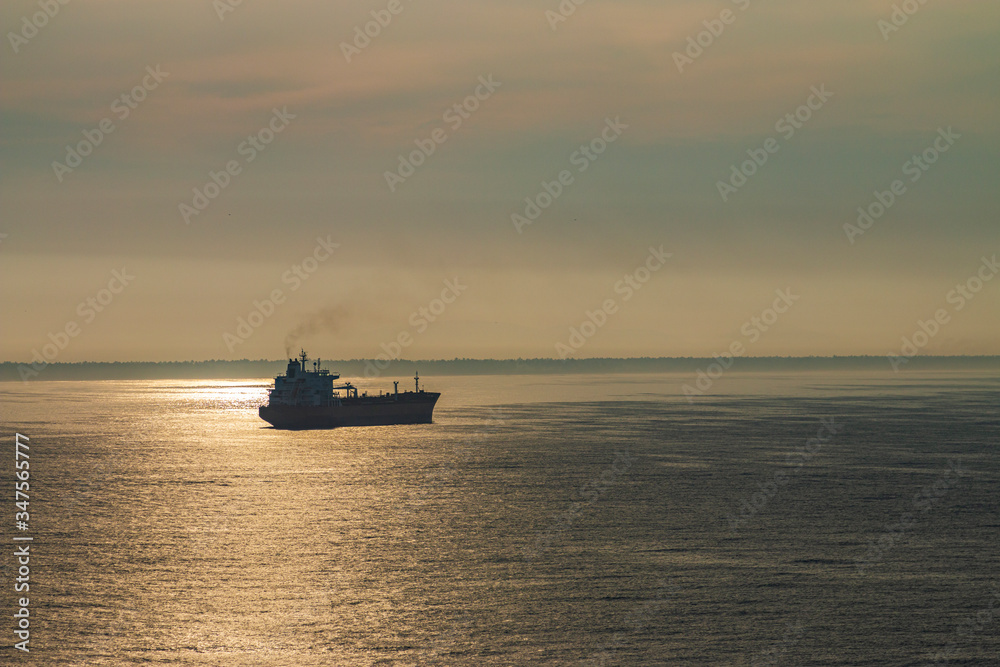 Cargo ship in the ocean. Ship at sunset.