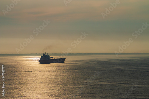 Cargo ship in the ocean. Ship at sunset. © rubchikova