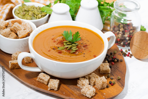 soup of pumpkin and lentils and ingredients on wooden board
