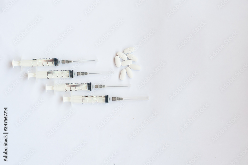 pills and syringes on a white background pills and syringes on a white background