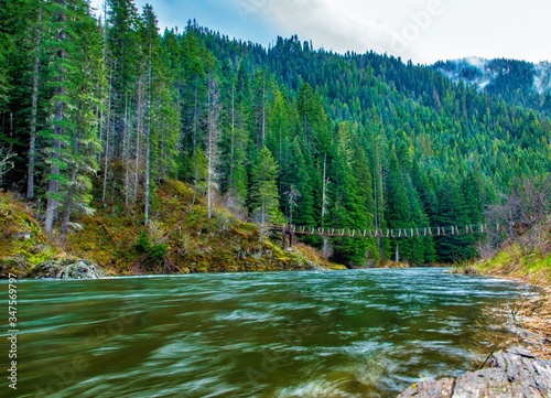 Fotografía Tight walking bridge for Saint Joe river with forest background