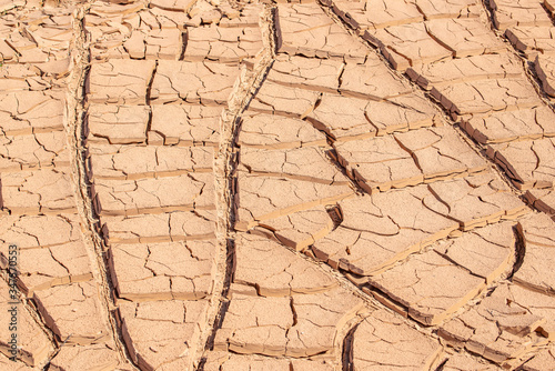 Deep cracks in desert clay textured background pattern from a dried pool in an aird wash after the water evaporated photo