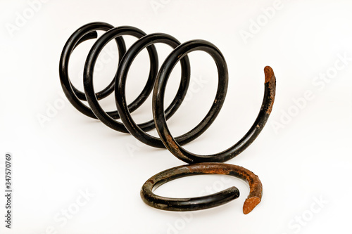 Broken front spring of a modern vehicle on a white background