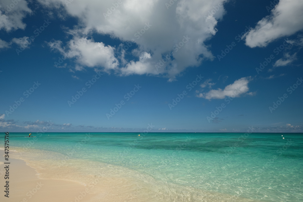 Crystal clear waters and pinkish sands on empty seven mile beach on tropical carribean Grand Cayman Island