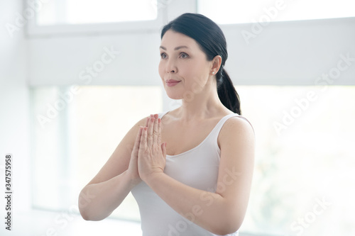 Brunette female performing namaste, pressing hands together Free Download Brunette female performing namaste, pressing hands together - GFXLoad