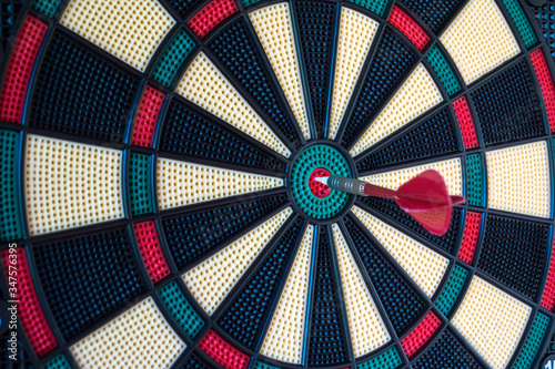 Dartboard with hit bullseye hanging on wall