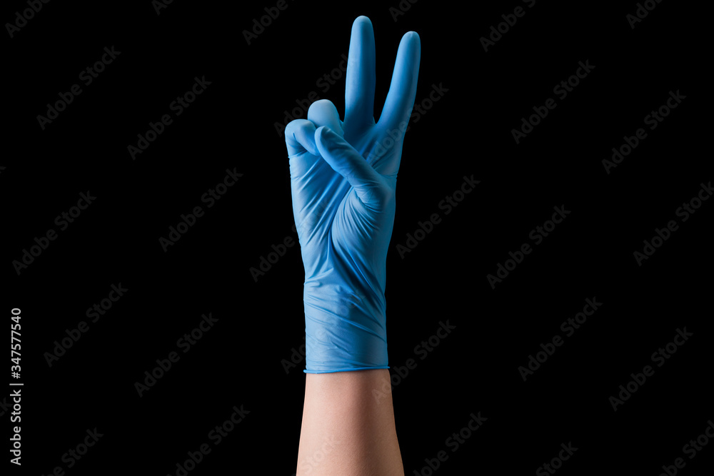 Doctor's hand in medical gloves showing two fingers up in peace symbol isolated Doctor's hand in medical gloves showing two fingers up in peace symbol isolated