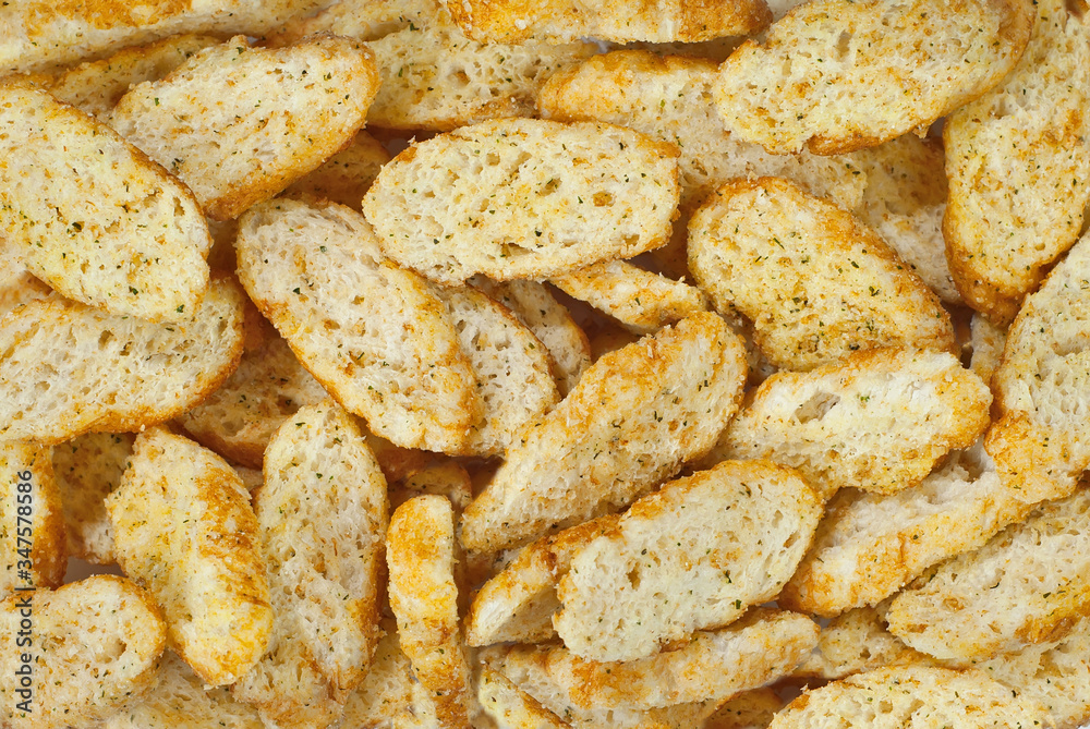 Yellow crackers close up. Texture of breadcrumbs. Many pieces of white dry bread.