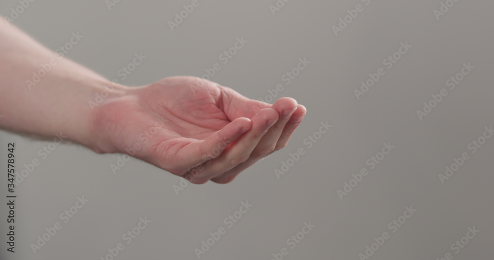 man stretches empty cupped hand on neutral background man stretches empty cupped hand on neutral background