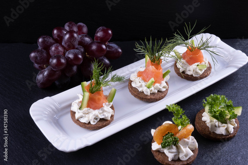 sandwiches of smoked salmon, shrimp, dill and sauce on a plate