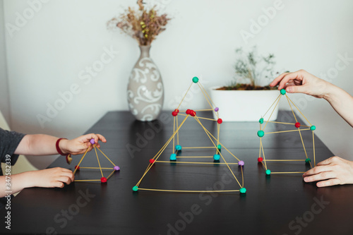 Mother and son  making geometric shapes from sticks and play dough.