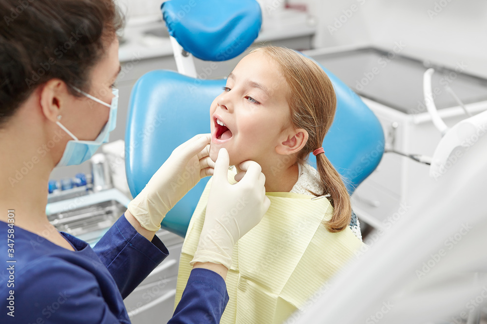 A little child in the examination at the dentist. Observation of teeth of young patient.