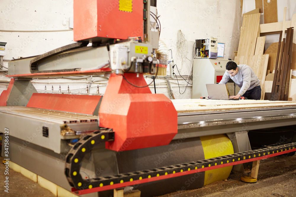 Fototapeta premium Man at the CNC machine. Tool with computer numerical control.