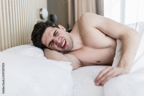 Handsome young man dreaming and sleeping on pillow in bed