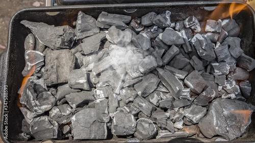 Cinemagraph of smoke on burnt coal in a BBQ grill. Close up top view, loop with selective focus.