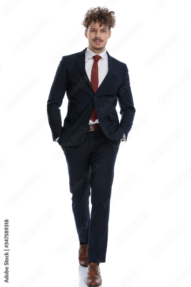 Confident businessman holding both hands in his pockets Confident businessman holding both hands in his pockets