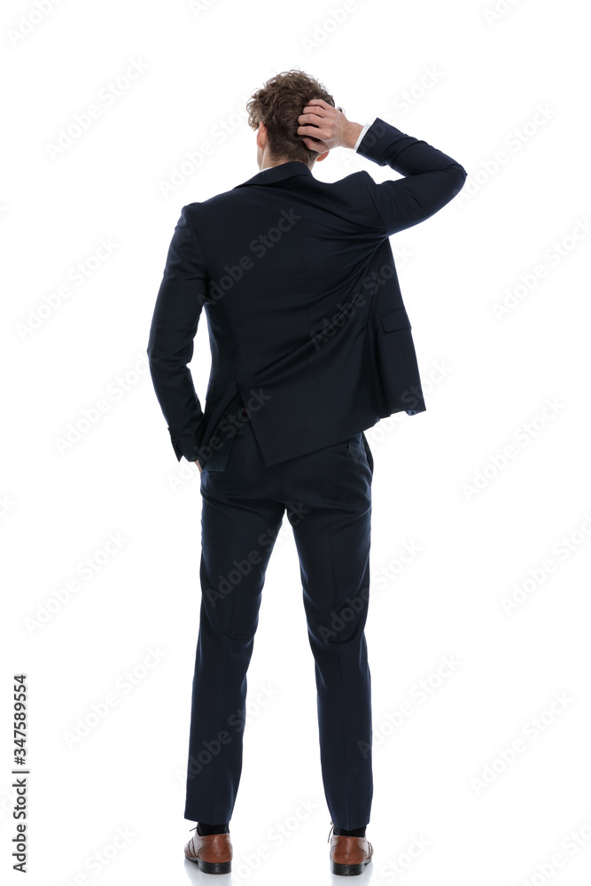 Rear view confused businessman scratching his head Rear view confused businessman scratching his head