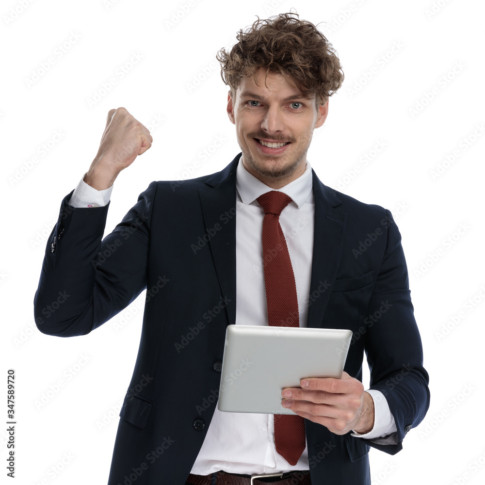 Cheerful businessman holding tablet and celebrating Cheerful businessman holding tablet and celebrating