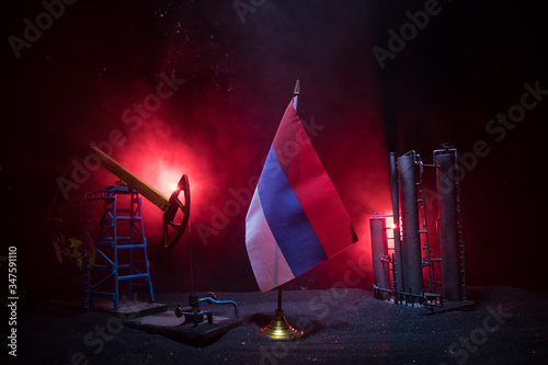 Business dialogue, oil agreement concept: National flags with Oil pump and oil refining factory at night with fog and backlight. Energy industrial concept. © zef art