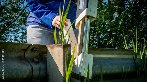 a geocacher pulls the geocache out of of a street marking hiding place photo