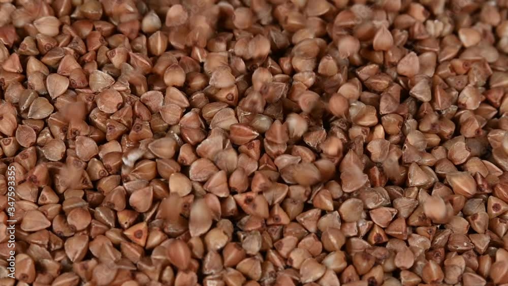 Close up brown buckwheat falls on heap Close up brown buckwheat falls on heap