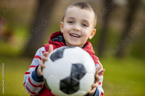 Happy little boy holding ball outdoors © Sanja_85