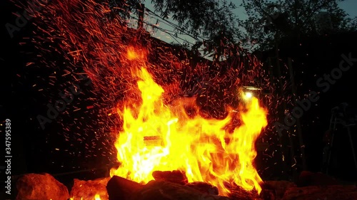 Cinemagraph of sparks rises from a bonfire at night. Loop with selective focus.