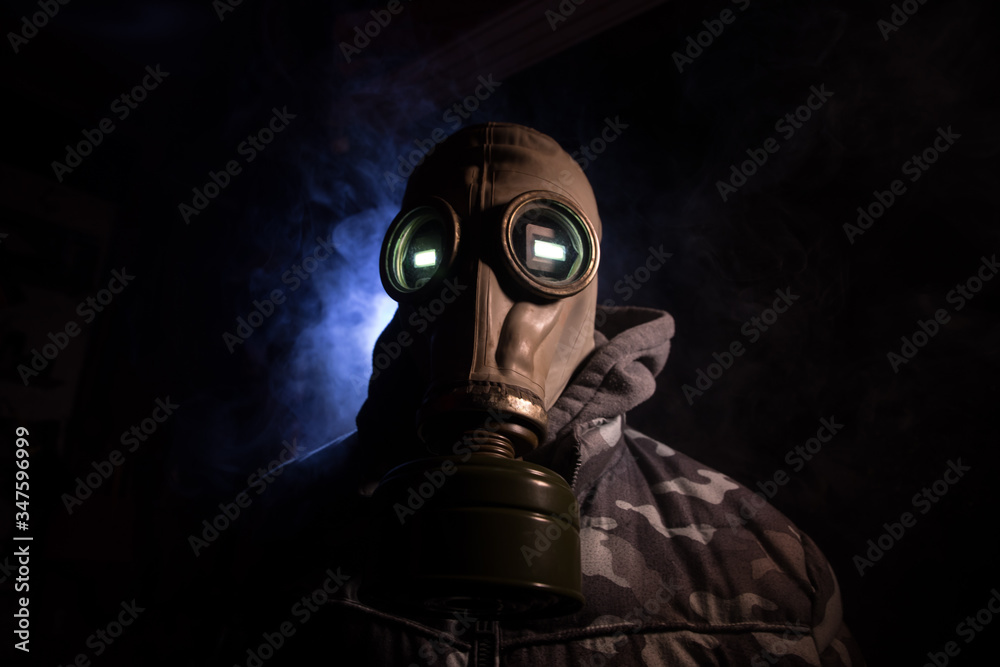 Gas mask with clouds of smoke on a dark background. Sign of radioactive contamination. Means for radiation protection. Danger of carbon monoxide poisoning.