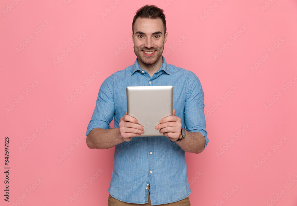 casual man holding his tablet in front of the camera casual man holding his tablet in front of the camera