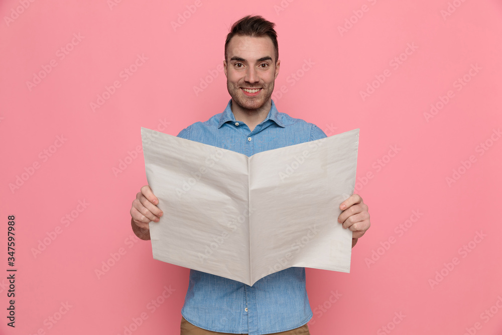 casual man reading the newspaper, smiling