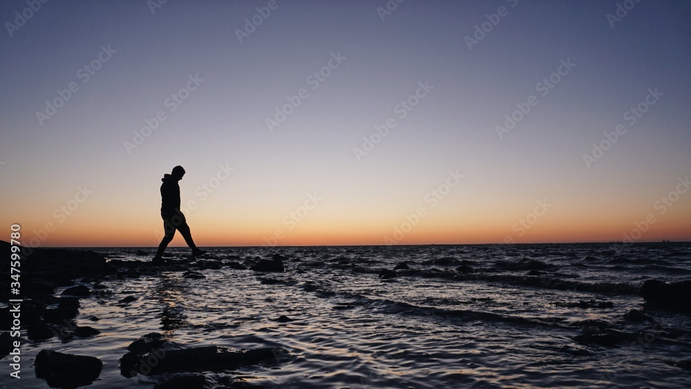 silhouette of a man running on the beach