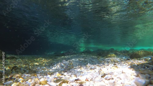 Underwater video of emerald Soča river, moving towards the surface, slow motion, UHD