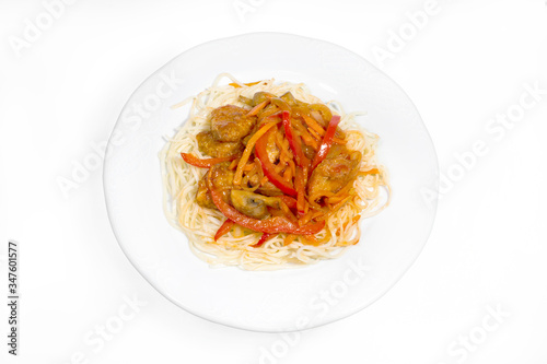 Boiled noodles with gravy of vegetables, chicken breast and mushrooms on a white plate on a white background