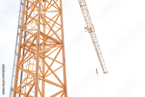 Tall, yellow construction crane against a white sky.
