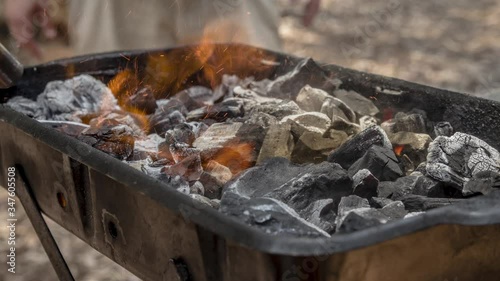 Cinemagraph of a burning fire on burnt coal in a BBQ grill. Close up, loop with selective focus.