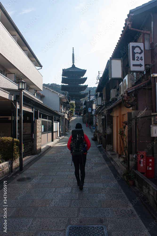 A woman walking in a street in Gion towards the Yasaka Tower in Kyoto, Japan