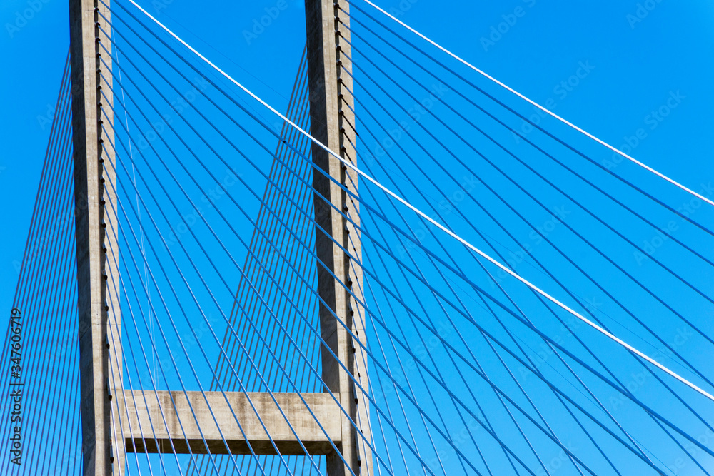 Cables of a suspension bridge create an abstract composition, and represent the concept of infrastructure. Cables of a suspension bridge create an abstract composition, and represent the concept of infrastructure.