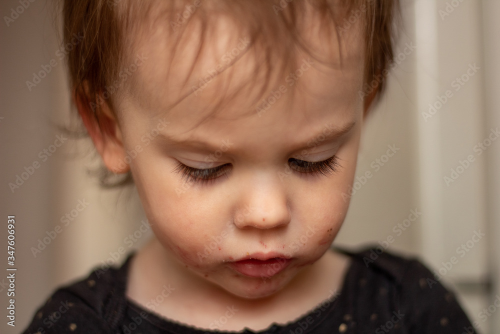 Close-up portrait of a little cute white baby with a dirty face in soft light and blurry background Close-up portrait of a little cute white baby with a dirty face in soft light and blurry background