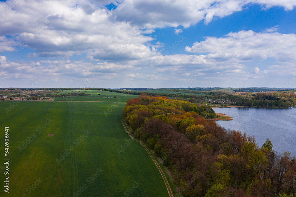 Aerial view on Navariya Lake (Shchyrka Reservoir), forest and field from drone