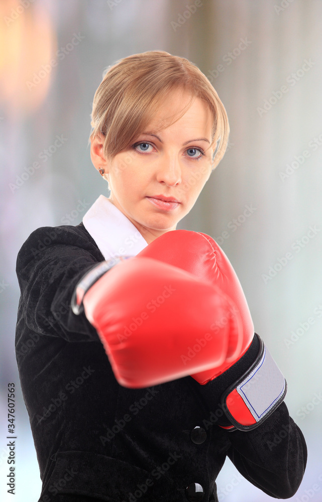 Portrait of  young female entrepreneur wearing boxing gloves