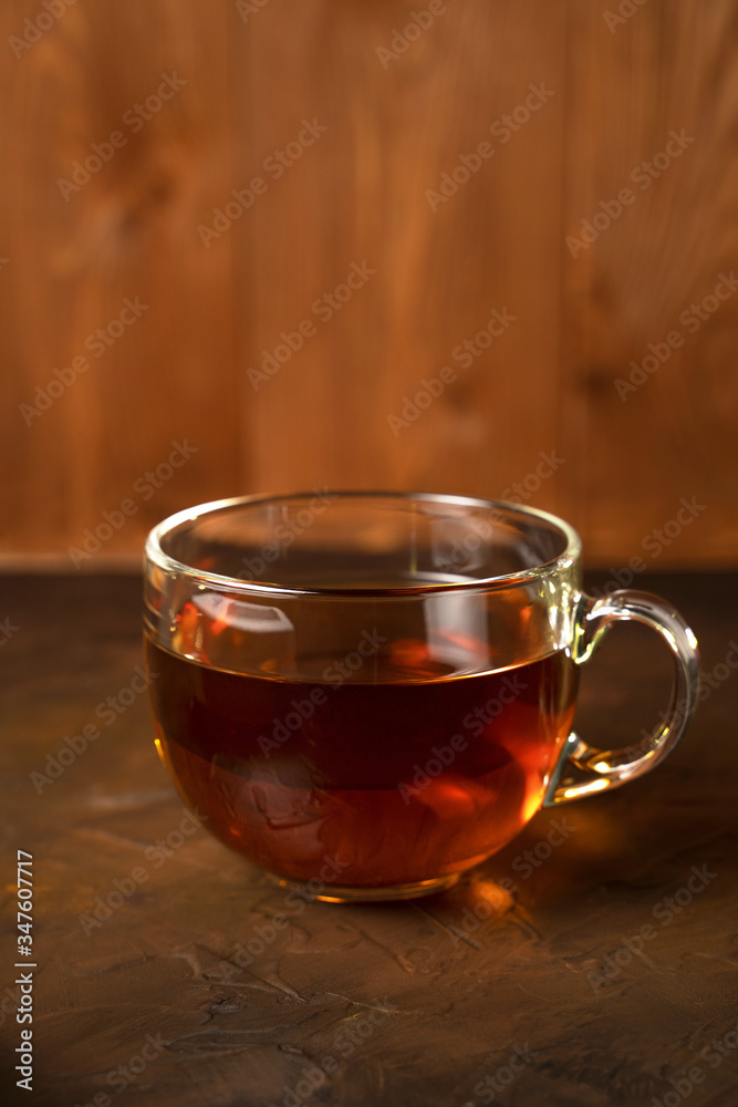 Transparent Cup with fragrant black tea on a blackboard on a natural background. Concept for your design, advertising. Transparent Cup with fragrant black tea on a blackboard on a natural background. Concept for your design, advertising.